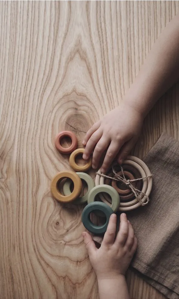 A hand holding a timber structure — a detail of timber craftsmanship.